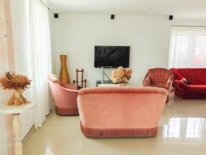 a living room with two chairs and a tv at Dorupes House in Liepāja