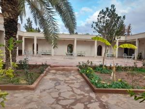 a courtyard of a building with tables and chairs at Riad NACIRIA in Aït Ourir