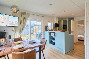 a dining room and kitchen with a table and chairs at Ostseecamp Salt & Sea in Scharbeutz
