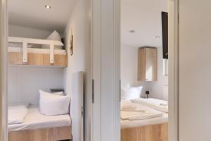 a room with two bunk beds and a doorway at Ostseecamp Salt & Sea in Scharbeutz