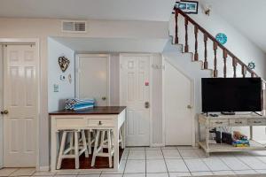 a living room with a tv and a staircase at Leeward Cove B4 in Padre Island