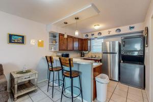 a kitchen with a counter and two bar stools at Leeward Cove B4 in Padre Island