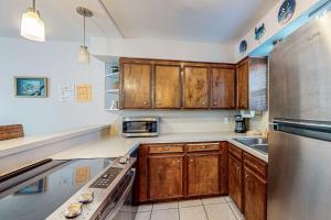 a kitchen with wooden cabinets and a stainless steel refrigerator at Leeward Cove B4 in Padre Island