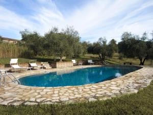 a swimming pool in a yard with chairs and trees at Tuscan Farmhouses at Castello del Calcione Estate in Lucignano +53 photos