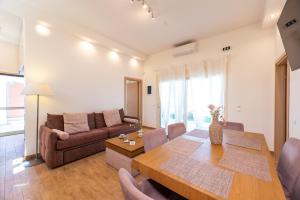 a living room with a table and a couch at AeroHill Suites Near Athens Airport By SEM in Artemida