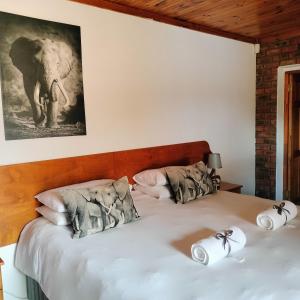 a bedroom with a bed with two pillows and an elephant at The Bay Inn in Port Elizabeth +171 photos