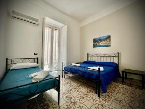 a bedroom with two beds and a window at B&B Resto al Sud 2 in Salerno
