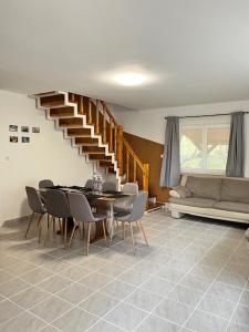 a dining room with a table and chairs and a staircase at Demeter Vendégház in Tiszanána +14 photos
