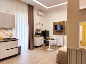 a room with a bed and a kitchen with a table at Dimora Alfinito in Salerno