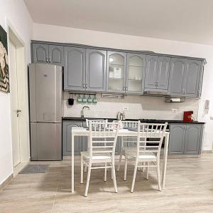 a kitchen with a table and chairs and a refrigerator at VERA apartament in Fushë-Draç