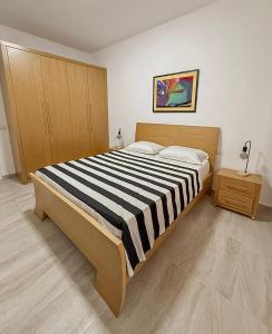 a bedroom with a bed with a black and white striped blanket at VERA apartament in Fushë-Draç