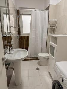 a white bathroom with a sink and a toilet at VERA apartament in Fushë-Draç +10 photos