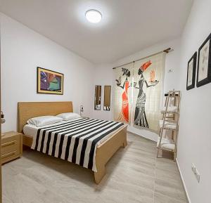 a bedroom with a bed and paintings on the wall at VERA apartament in Fushë-Draç