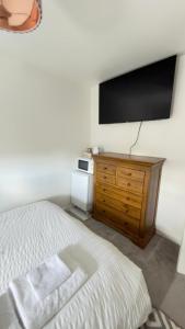 a bedroom with a bed and a flat screen tv at Suite 3 En-suite Room with Double Bed in Edinburgh