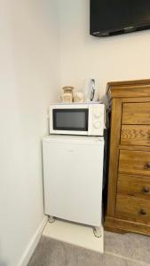 a microwave sitting on top of a white refrigerator at Suite 3 En-suite Room with Double Bed in Edinburgh +2 photos
