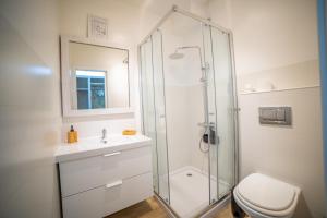 a bathroom with a shower and a toilet and a sink at Saltline Surf House Ericeira in Ericeira