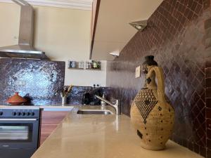 a kitchen with a large vase sitting on the counter at Villa Adan in Sidi Salah