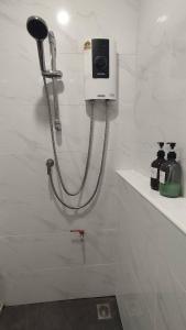 a shower in a white bathroom with a hose at บ้านฮา พอชเทล Baan Ha Poshtel in Nan +59 photos
