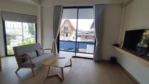 a living room with a couch and a coffee table at บ้านฮา พอชเทล Baan Ha Poshtel in Nan