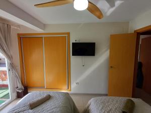 a bedroom with a bed and a tv on the wall at ÁTICO HOME y Garaje, Algemesi Home in Algemesí