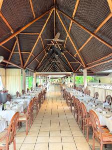 a long row of tables and chairs in a restaurant at Travellers Beach Hotel & SPA in Mombasa