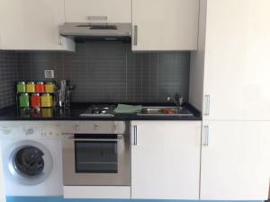 a kitchen with a sink and a washing machine at Studio with private beach Folla Residence in Akouda
