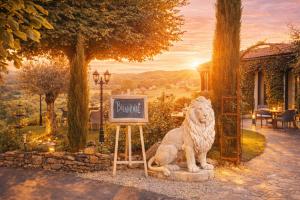 a statue of a lion sitting next to a chalkboard at Hôtel Bien-Être Aux Cyprès de Marquay-Calme et élégance-Laissez-vous porter par une ambiance chaleureuse où chaque instant compte-Découvrez un havre de paix où nature et confort se marient pour vous offrir une expérience unique- Réservez dès aujourd'hui ! in Marquay