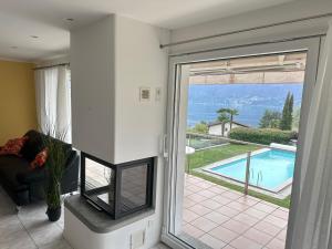 a living room with a sliding glass door leading to a swimming pool at HOLIDAY Residence Sette Nani in San Nazzaro