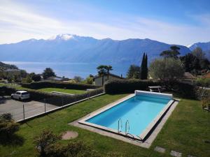 a swimming pool in a yard with a view of the mountains at HOLIDAY Residence Sette Nani in San Nazzaro