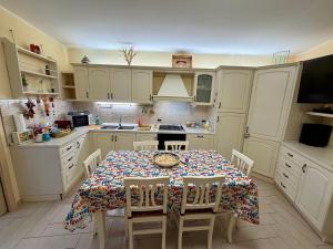 a kitchen with a table and chairs and a kitchen with white cabinets at Casa Etna Soul in Paterno
