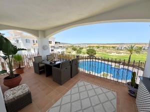 a patio with a table and chairs and a pool at Casa Sofinata with Pool View & Golf in Sucina