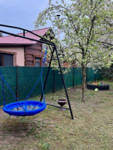 a swing in a yard with a tree at Demeter Vendégház in Tiszanána