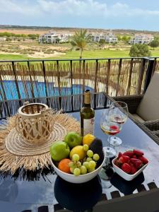 a bowl of fruit and a bottle of wine on a table at Casa Sofinata with Pool View & Golf in Sucina