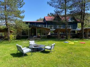 a group of chairs and a table in front of a house at pınar kır evi in Artvin