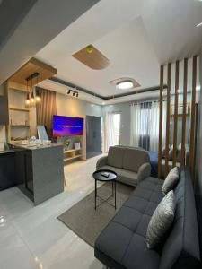 a living room with a couch and a desk with a tv at Ohhlala Cozy Corner at Royal Oceancrest Mactan in Mactan Island