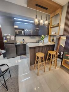 a kitchen with two bar stools and a counter at Ohhlala Cozy Corner at Royal Oceancrest Mactan in Mactan Island