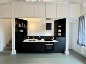 a kitchen with black and white cabinets and a sink at Schloss Prossen in Bad Schandau +73 photos