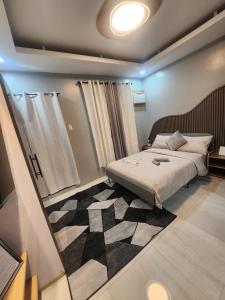 a bedroom with a bed and a rug at Ohhlala Cozy Corner at Royal Oceancrest Mactan in Mactan Island +36 photos