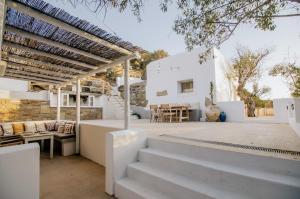 a white house with stairs and a patio at Ios Pearls-2 houses in Mylopotas