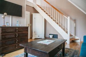 a living room with a wooden table and a staircase at Haus am Kiel in Ahrenshoop