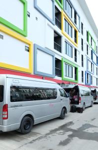 two white vans parked in front of a building at Sunny Residence in Lat Krabang