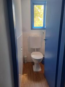 a white toilet in a bathroom with a window at Amit house in Pardes H̱anna +6 photos