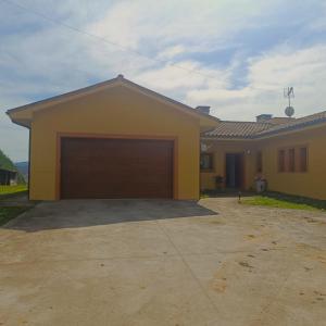 a yellow house with a large garage at My Reyna in San Miguel
