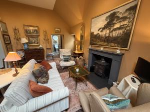 a living room with a white couch and a fireplace at Barns Studio in Peebles