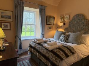 a bedroom with a large bed with towels on it at Barns Studio in Peebles