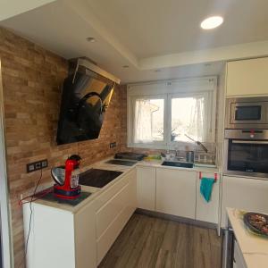 a kitchen with white cabinets and a sink and a window at My Reyna in San Miguel