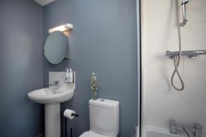 a bathroom with a toilet and a sink and a shower at The View in Sidmouth