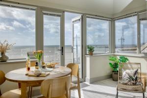 a dining room with a table and chairs and windows at The View in Sidmouth