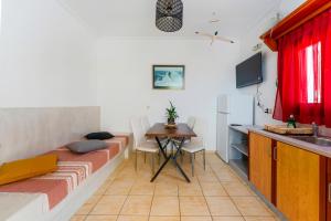 a room with a bed and a table and a kitchen at Birds Villa Apartments with Heated Pool - Including Car and Breakfast in Perissa