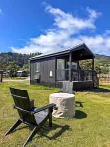 a chair and a table in front of a cabin at Roam Tillamook in Garibaldi